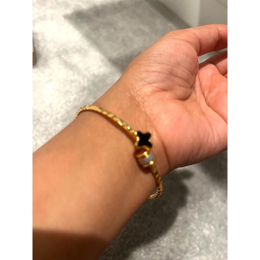 Gold-colored bangle with black quatrefoil and silver charm - Picture 2 of 5